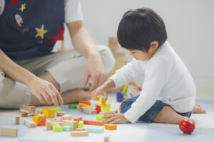 親子で木製の積み木を並べて遊ぶ様子